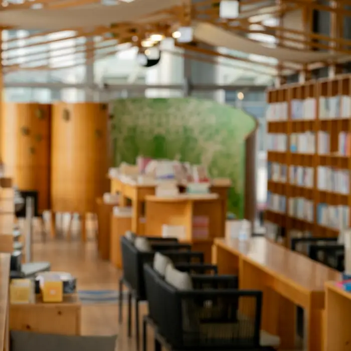 A bright bookshop with wooden shelves, reading tables and daylight