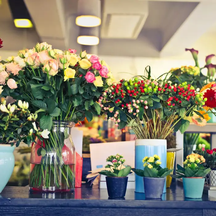 Fresh bouquets of roses and gerberas in a bright flower boutique
